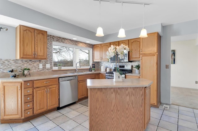 kitchen featuring backsplash, light countertops, light tile patterned floors, stainless steel appliances, and a sink