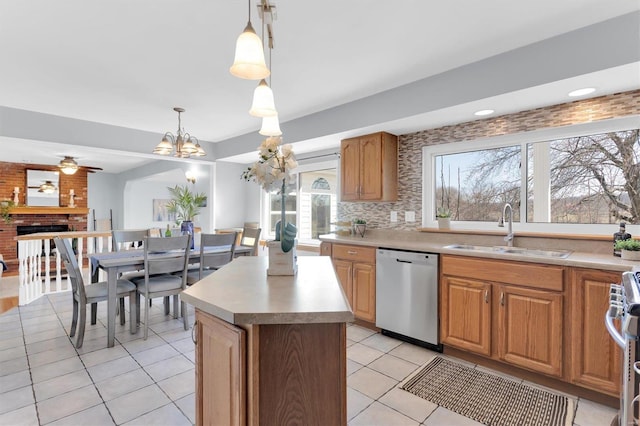 kitchen featuring tasteful backsplash, light tile patterned floors, a fireplace, stainless steel appliances, and a sink