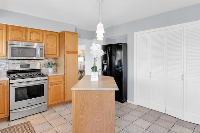 kitchen featuring backsplash, a kitchen island, appliances with stainless steel finishes, light tile patterned flooring, and light countertops