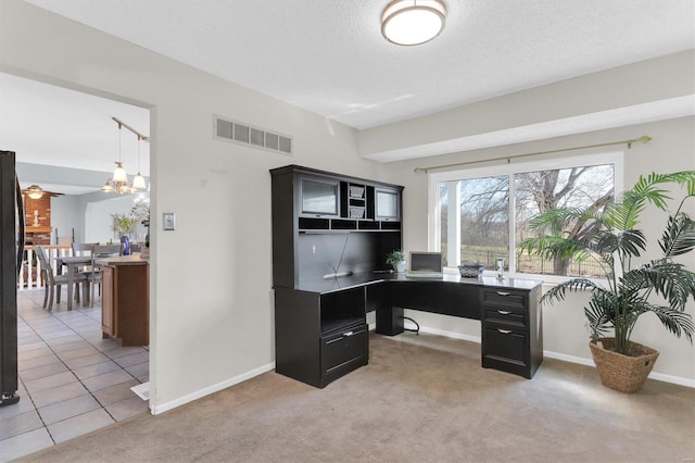 home office featuring visible vents, baseboards, light carpet, light tile patterned floors, and a textured ceiling