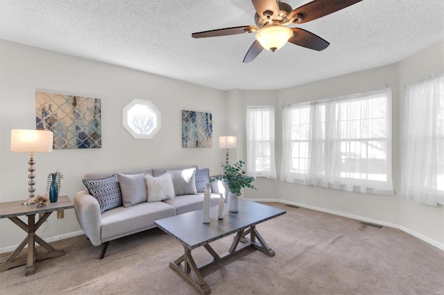 living area featuring visible vents, a textured ceiling, baseboards, and carpet floors