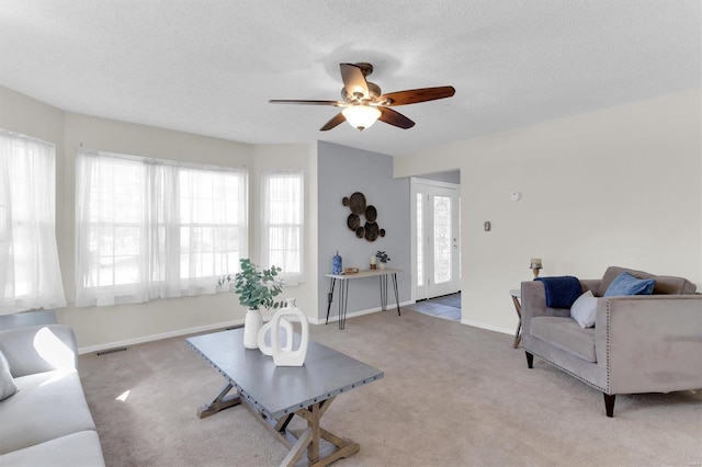 living room with baseboards, visible vents, carpet floors, and a textured ceiling