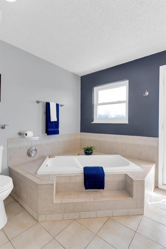 bathroom featuring a textured ceiling, toilet, a bath, and tile patterned flooring