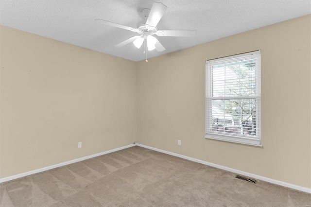 spare room with visible vents, baseboards, a textured ceiling, and carpet flooring