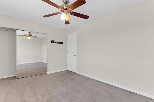 unfurnished bedroom featuring a closet, carpet flooring, ceiling fan, and baseboards