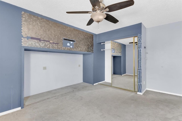 carpeted spare room featuring a textured ceiling and ceiling fan