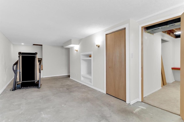 finished below grade area featuring built in shelves and baseboards