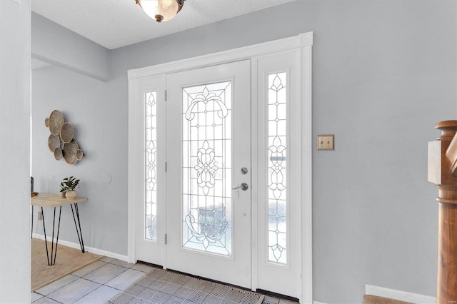 foyer featuring light tile patterned floors and baseboards