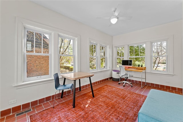 sunroom / solarium with a ceiling fan and visible vents