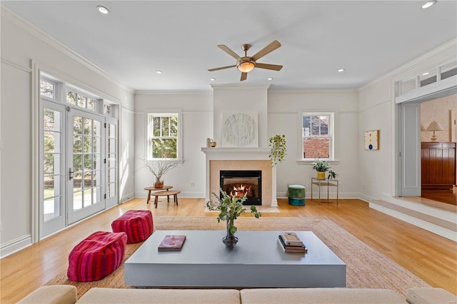 living room with crown molding, baseboards, a fireplace with flush hearth, recessed lighting, and wood finished floors