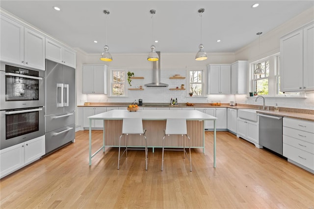 kitchen featuring appliances with stainless steel finishes, crown molding, a kitchen breakfast bar, and a sink