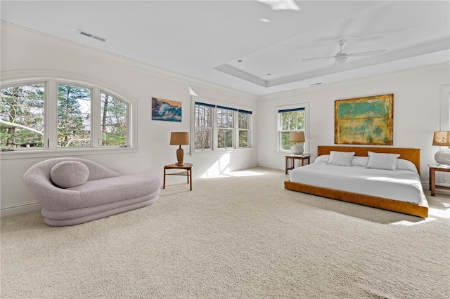 carpeted bedroom with visible vents, crown molding, a raised ceiling, and baseboards