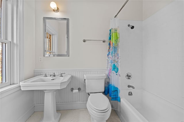 full bathroom featuring shower / tub combo, toilet, and wainscoting