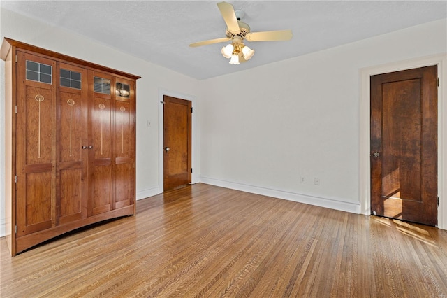 unfurnished bedroom featuring ceiling fan, baseboards, and light wood-style flooring