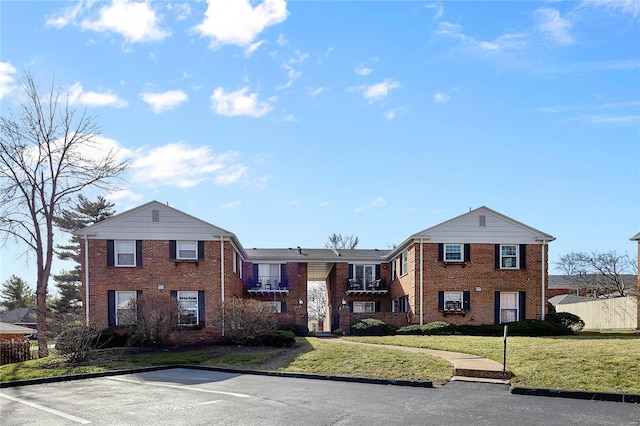 view of front of property featuring a front yard and brick siding