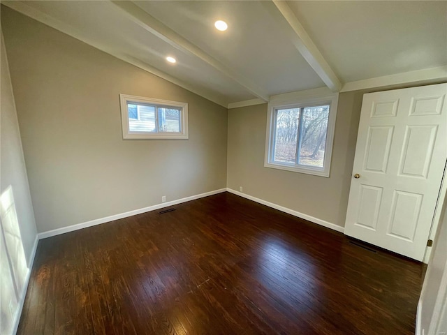 interior space featuring dark wood-style floors, multiple windows, vaulted ceiling with beams, and baseboards