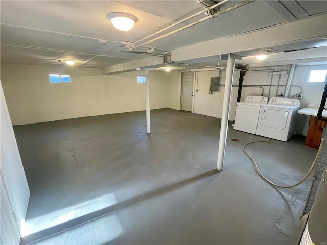 basement with washing machine and clothes dryer and electric panel