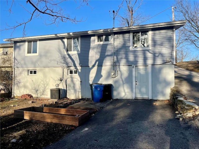 rear view of house featuring cooling unit and stucco siding