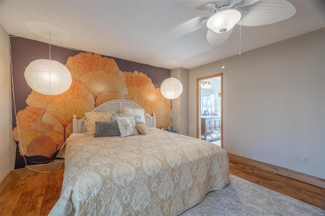 bedroom with a ceiling fan, wood finished floors, baseboards, and a textured ceiling