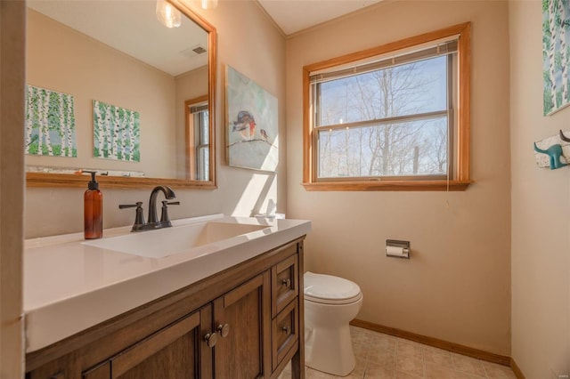 bathroom with vanity, toilet, visible vents, and baseboards