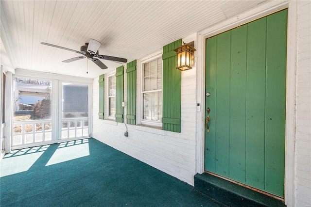 unfurnished sunroom featuring ceiling fan