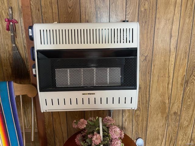 room details featuring heating unit and wooden walls