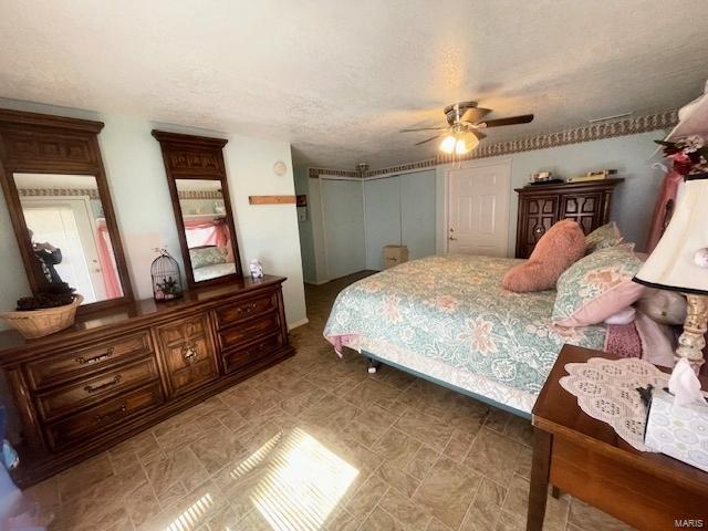 bedroom with a textured ceiling and ceiling fan