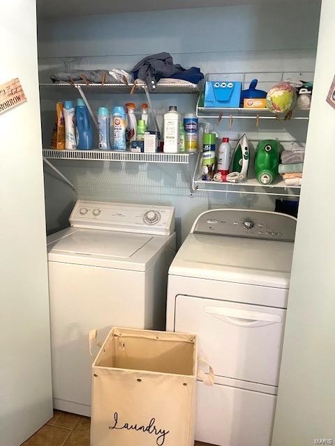 laundry area featuring washer and dryer, laundry area, and tile patterned flooring