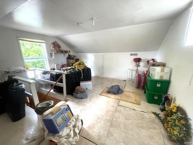 additional living space with lofted ceiling and visible vents