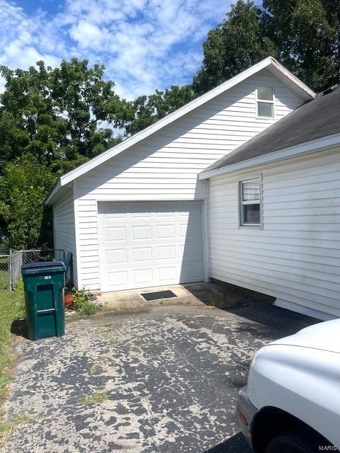 view of side of home with a garage and driveway