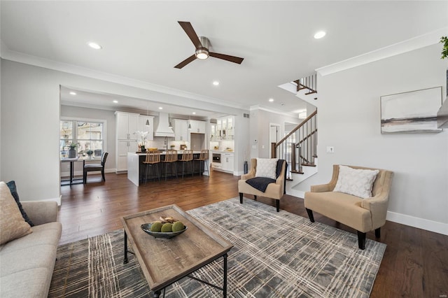 living room featuring dark wood-style floors, stairway, baseboards, and ornamental molding