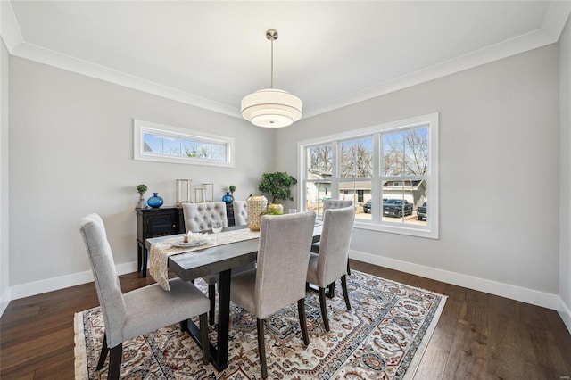 dining room with crown molding, baseboards, and hardwood / wood-style flooring