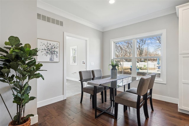 dining space with ornamental molding, dark wood-style floors, visible vents, and baseboards