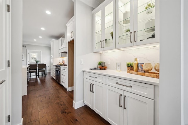 bar featuring recessed lighting, dark wood-style flooring, ornamental molding, decorative backsplash, and high end stainless steel range oven