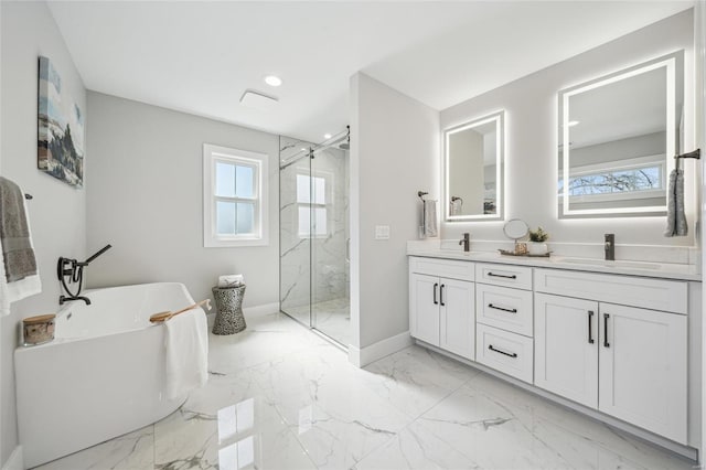 full bath featuring a freestanding tub, marble finish floor, a marble finish shower, and a sink