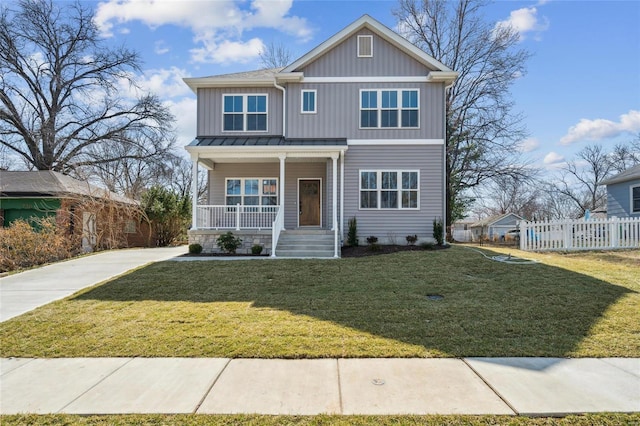 view of front of house with a front yard, fence, a standing seam roof, a porch, and board and batten siding