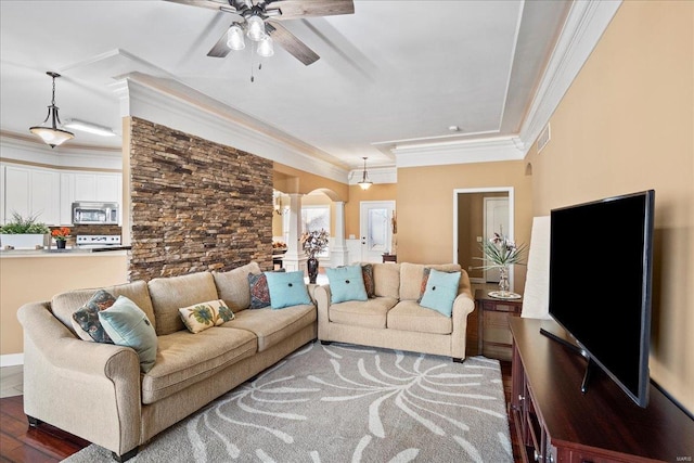 living room featuring visible vents, ornamental molding, wood finished floors, arched walkways, and ceiling fan