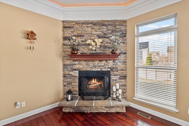 unfurnished living room featuring visible vents, crown molding, baseboards, and wood finished floors