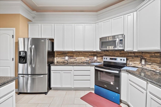 kitchen with dark stone counters, white cabinets, and appliances with stainless steel finishes