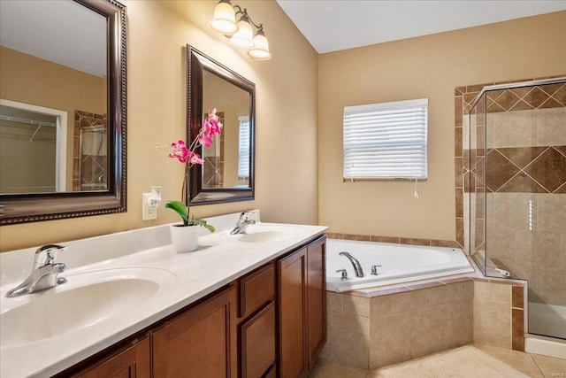 bathroom with tile patterned flooring, a stall shower, a garden tub, and a sink