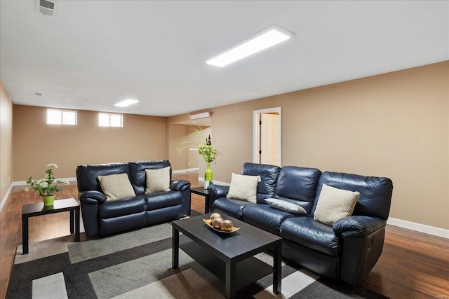 living area featuring visible vents, wood finished floors, and baseboards