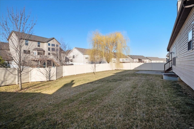 view of yard featuring a residential view, a patio, and a fenced backyard