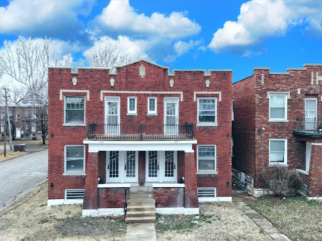 townhome / multi-family property featuring a balcony and brick siding