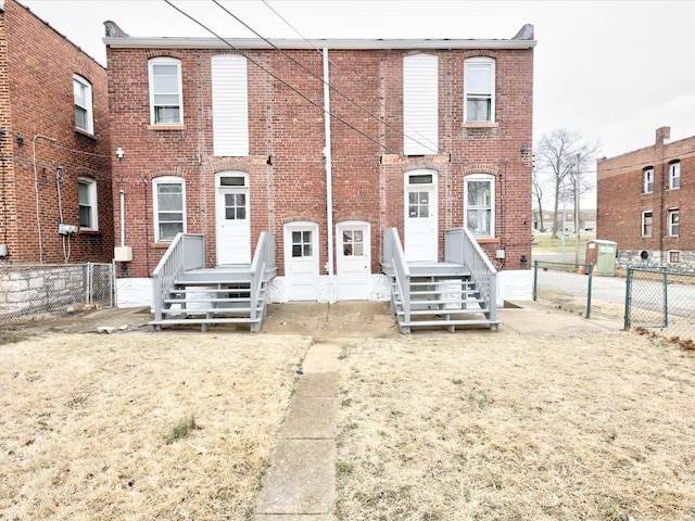 view of front facade with brick siding and fence