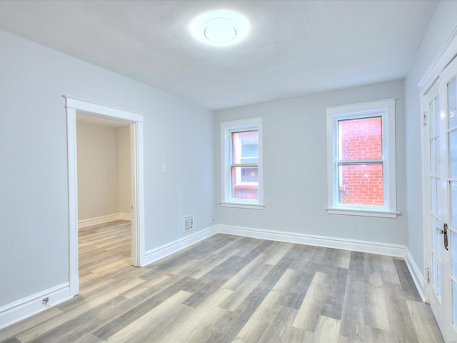 unfurnished room featuring light wood-style floors and baseboards