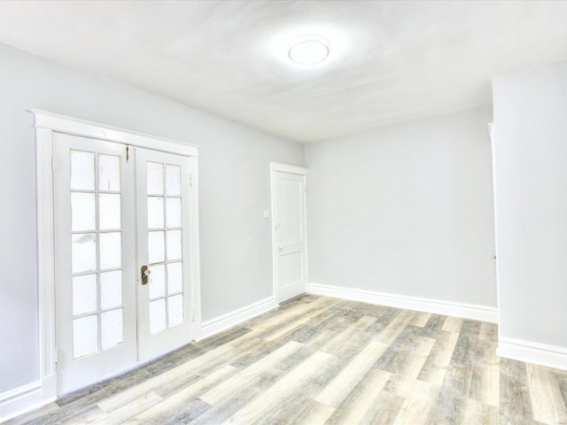 unfurnished room featuring french doors, baseboards, and wood finished floors