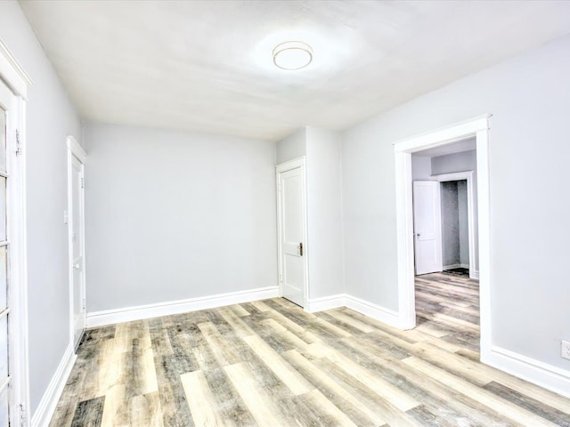 unfurnished room featuring baseboards and wood finished floors