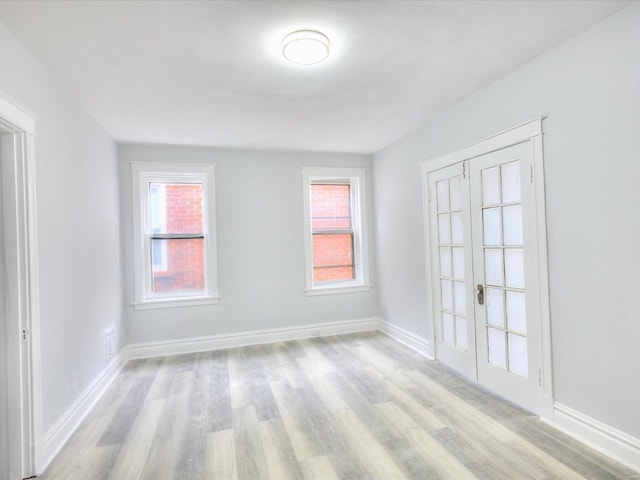 spare room with light wood-style flooring and baseboards