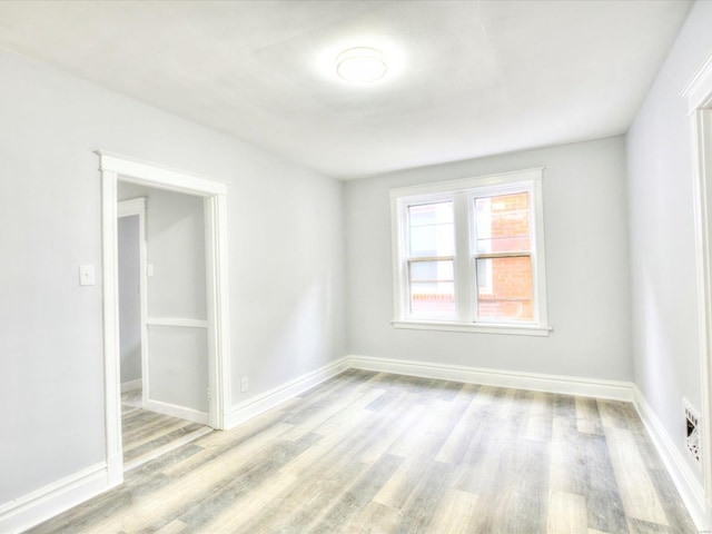 unfurnished room featuring baseboards and wood finished floors