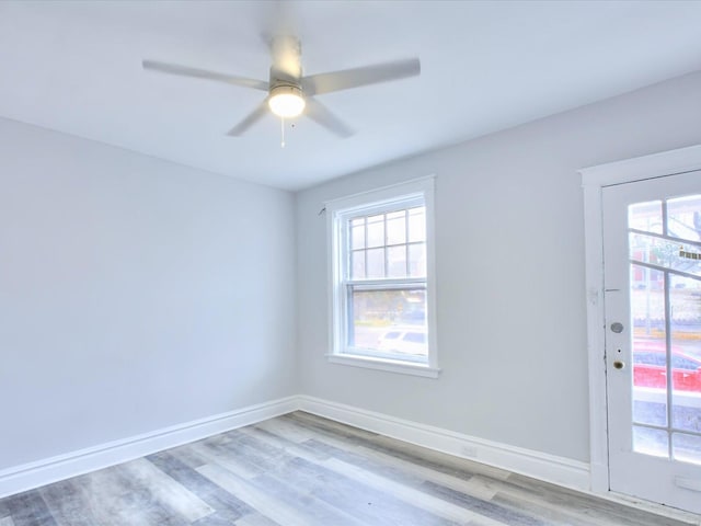 spare room featuring a ceiling fan, baseboards, and wood finished floors